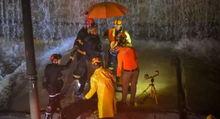 Tim penyelamat mencari orang-orang yang terperangkap di bawah tembok yang runtuh menimpa beberapa kendaraan setelah hujan lebat di 27 de Febrero Avenue di Santo Domingo pada 18 November 2023 /AFP
