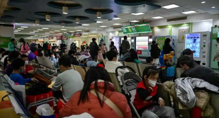 Anak-anak dan orang tua mereka menunggu di area rawat jalan di rumah sakit anak-anak di Beijing pada 23 November 2023 /AFP