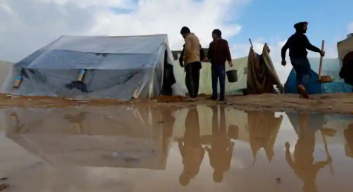 Warga Palestina yang mengungsi di Rafah, yang meninggalkan rumah mereka karena serangan Israel, berjalan di samping tenda setelah hujan lebat di kamp-kamp tenda, ketika konflik antara Israel dan Hamas berlanjut /net