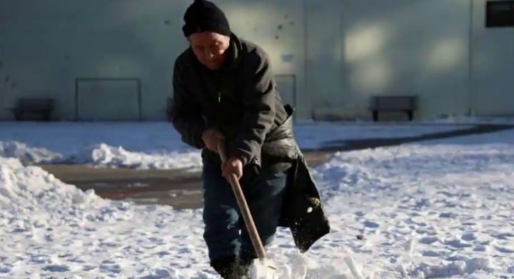Seorang pekerja membersihkan salju di sebuah taman selama titik balik matahari musim dingin di Beijing, China 22 Desember 2023 /Reuters