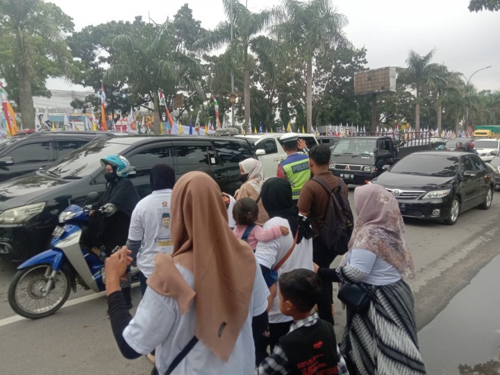 Petugas Satlantas terlihat membantu masyarakat menyebrang ke lokasi acara kedatangan Paslon Presiden Prabowo Subianto ke Pekanbaru.