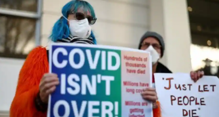 Pengunjuk rasa memegang plakat di luar gedung Penyelidikan Covid 19 Inggris di London barat /AFP