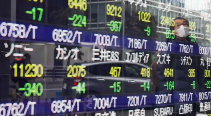 Seorang pria tercermin di papan kutipan saham di Tokyo, Jepang /Reuters