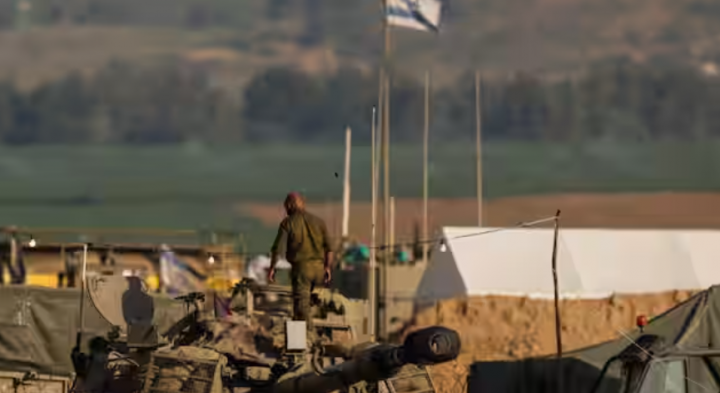 Seorang tentara Israel berjalan di atas unit artileri bergerak, di tengah konflik yang sedang berlangsung antara Israel dan kelompok Islam Palestina Hamas, dekat perbatasan Israel-Gaza di Israel selatan, 20 Januari 2024 /Reuters
