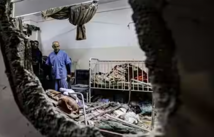 Orang-orang memeriksa kerusakan di sebuah ruangan setelah pemboman Israel di rumah sakit Nasser di Khan Yunis di Jalur Gaza selatan pada 17 Desember 2023 /AFP