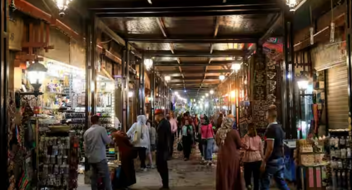 Orang-orang berjalan melalui gang toko suvenir di pasar turis di Luxor, Mesir /Reuters