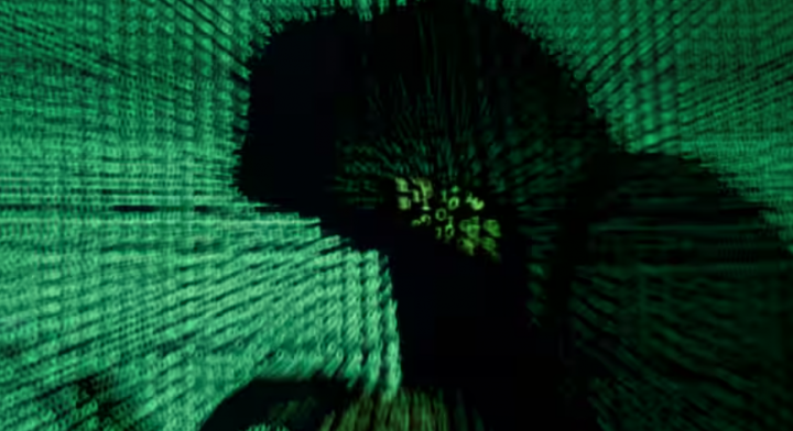 Seorang pria memegang komputer laptop sebagai kode cyber diproyeksikan pada dirinya dalam gambar ilustrasi /Reuters