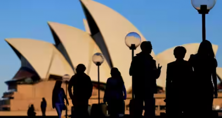 Orang-orang bersiluet di Sydney Opera House saat matahari terbenam di Australia /Reuters