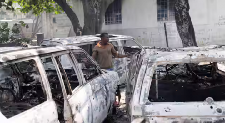 Gambar menunjukkan seorang pria di samping sisa-sisa kendaraan hangus di dekat istana presiden, di Port-au-Prince, Haiti /Reuters