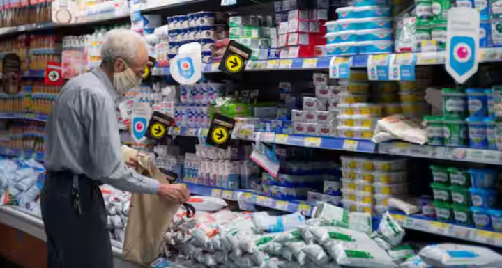 Seorang pria berdiri di samping produk susu di sebuah supermarket di pusat kota Buenos Aires /Reuters