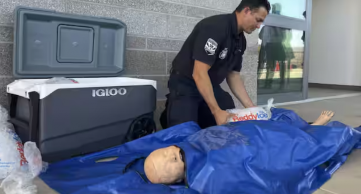 Kapten Pemadam Kebakaran Prato (dalam gambar) mendemonstrasikan metode pengemasan es batu di dalam kantong biru kedap air di sekitar boneka medis yang mewakili pasien /AP
