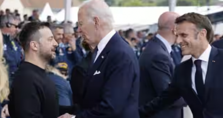 Presiden AS Joe Biden (tengah) berjabat tangan dengan Presiden Ukraina Volodymyr Zelensky (kiri) saat Presiden Prancis Emmanuel Macron (kanan) terlihat selama upacara peringatan Internasional di Pantai Omaha yang menandai peringatan 80 tahun pendaratan Sekutu 