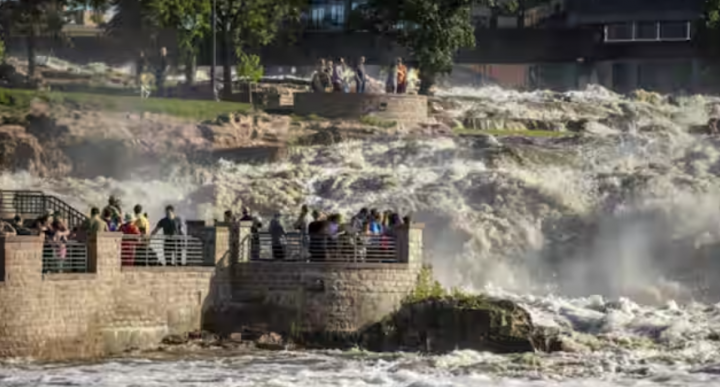 Foto dari 22 Juni 2024 ini menunjukkan keluarga yang memulai Falls Park di Sioux Falls saat air naik dengan cepat setelah hujan lebat berhari-hari menyebabkan banjir di daerah tersebut /Reuters