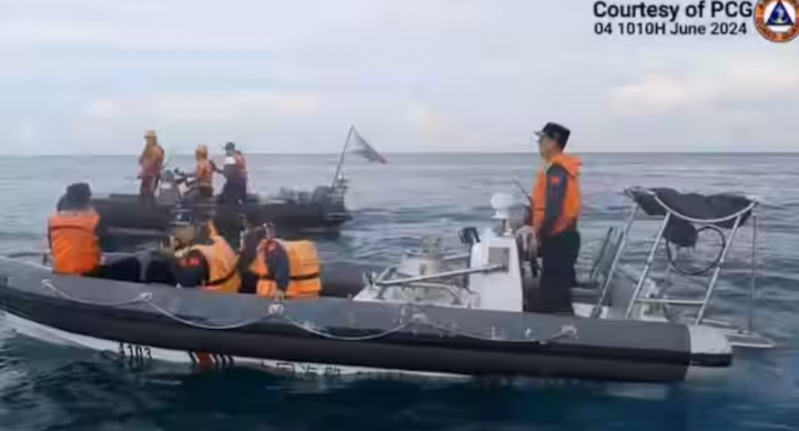 Foto selebaran yang diambil dari video yang dirilis oleh Penjaga Pantai Filipina pada 7 Juni 2024 ini menunjukkan personel Penjaga Pantai Tiongkok di atas kapal karet kaku mereka, menghalangi kapal karet kaku Penjaga Pantai Filipina (belakang) yang membawa ilmuwan kelautan di perairan Laut China Sel