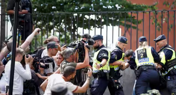 Petugas polisi turun tangan setelah reaksi orang-orang saat demonstran membakar Al-Qur'an di luar masjid pusat Stockholm di Stockholm /Reuters