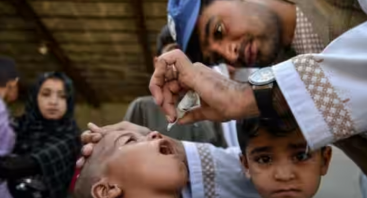 Gambar representatif-seorang petugas kesehatan memberikan tetes vaksin polio kepada seorang anak /AFP