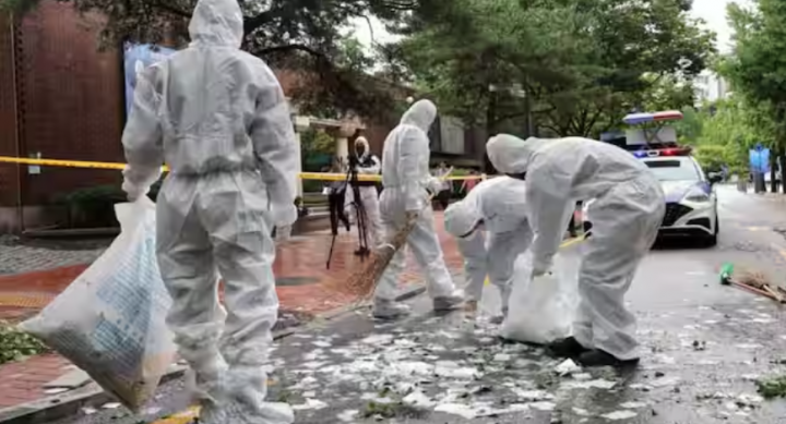 Pejabat Korea Selatan membersihkan isi balon pembawa sampah yang dikirim oleh Korea Utara setelah mendarat di sebuah jalan di Seoul pada 24 Juli 2024 /AFP