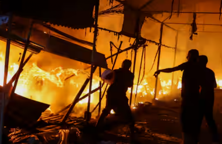 Foto dari 14 Oktober 2024 ini menunjukkan orang-orang berusaha memadamkan api di lokasi serangan Israel di tenda-tenda yang melindungi pengungsi di Deir Al-Balah di Jalur Gaza tengah /Reuters