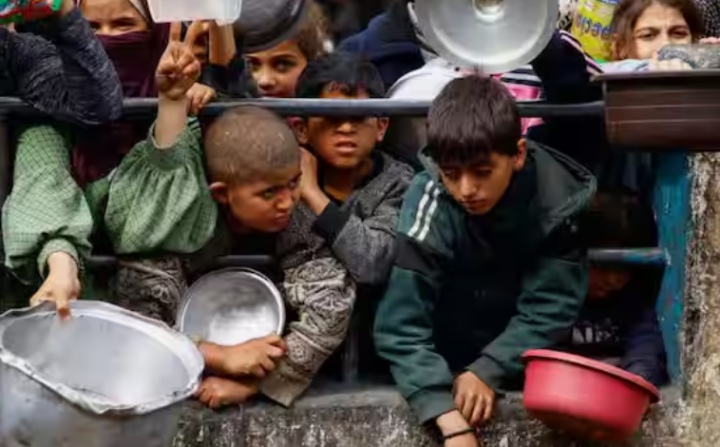 Anak-anak Palestina menunggu untuk menerima makanan yang dimasak oleh dapur amal di tengah kekurangan pasokan makanan, ketika konflik yang sedang berlangsung antara Israel dan kelompok Islam Palestina Hamas berlanjut, di Rafah, di Jalur Gaza selatan /Reuters