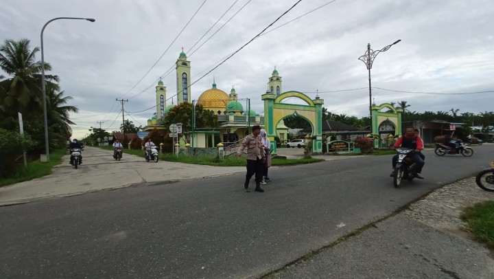 Wujud Kepedulian, Anggota Bhabinkamtibmas Bantu Anak Sekolah Menyebrang Jalan