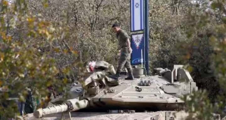 Seorang tentara Israel mengatur perlengkapan di atas tank tentara yang dikerahkan di Dataran Tinggi Golan yang dianeksasi Israel di sekitar zona penyangga demiliterisasi di Suriah barat daya pada 8 Desember 2024, setelah Damaskus jatuh ke tangan pasukan pemberontak /AFP