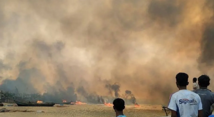 Foto dari 9 Januari 2025 ini menunjukkan orang-orang melihat rumah-rumah yang terbakar di lokasi serangan udara yang diduga dilakukan oleh militer Myanmar di desa Kyauk Ni Maw /AFP