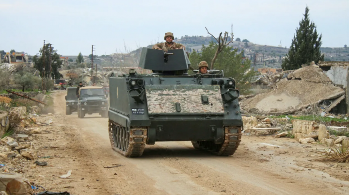 Kendaraan tentara Lebanon melewati gedung-gedung yang hancur di desa Yarin, Lebanon selatan pada 26 Januari 2025 /AFP