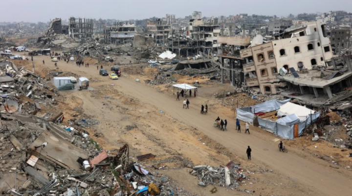 Orang-orang berjalan di tengah bangunan yang runtuh di sepanjang jalan Saftawi di Jabalia di Jalur Gaza utara pada 5 Februari 2025 selama kesepakatan gencatan senjata dalam perang antara Israel dan Hamas /AFP