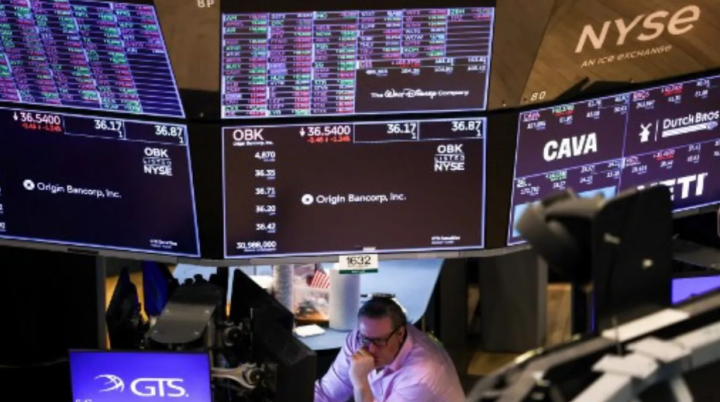 Seorang trader bekerja di lantai Bursa Efek New York (NYSE) pada bel pembukaan di New York City pada 10 Maret 2025 /AFP