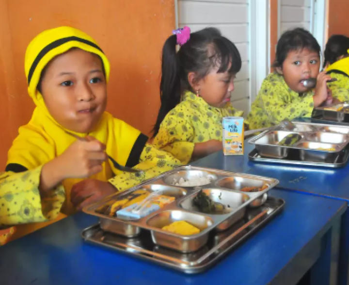 Anak-anak menyantap makan siang bantuan pemerintah di sebuah sekolah Islam di Kudus, Jawa Tengah pada 12 Februari 2025