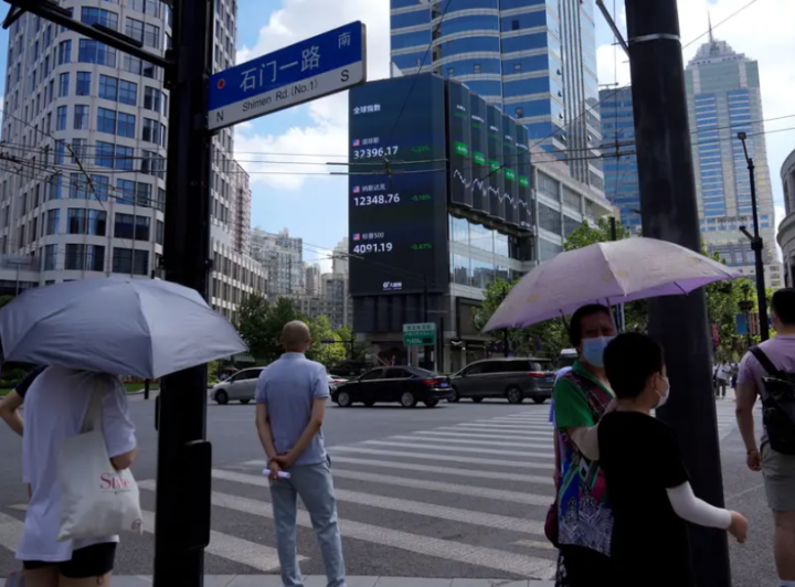 Pejalan kaki menunggu untuk menyeberang jalan di persimpangan dekat pameran indeks saham raksasa di Shanghai, Tiongkok /Reuters