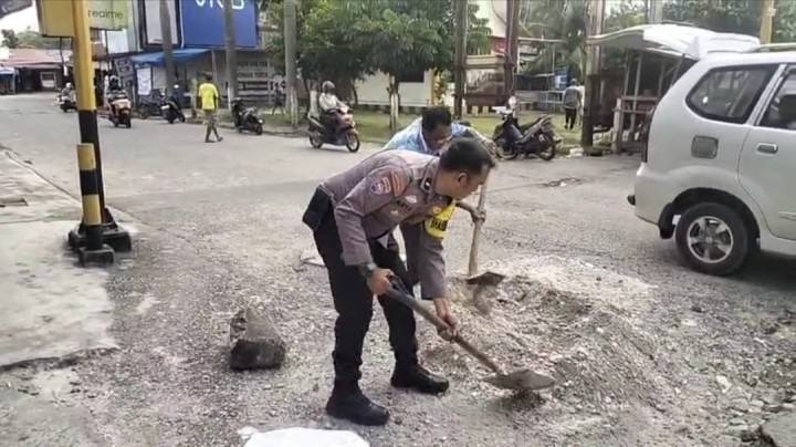 Sinergi Warga dan Bhabinkamtibmas, Jalan Berlubang di Perawang Akhirnya Ditambal