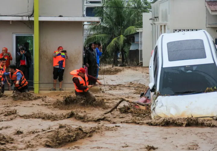 Tim penyelamat mengarungi banjir dengan memegang tali dalam upaya mengevakuasi warga yang terjebak di rumah mereka di Padang, Provinsi Sumatera Barat pada 27 November 2025/ ANI