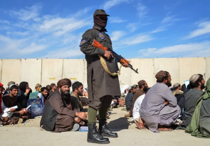Seorang personel keamanan Taliban bersenjata berdiri di samping mantan pecandu narkoba di distrik Daman, Kandahar/ AFP