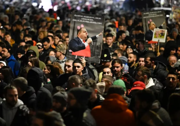 Para pengunjuk rasa membawa plakat politisi Bulgaria Delyan Peevski selama protes di Sofia/ AFP