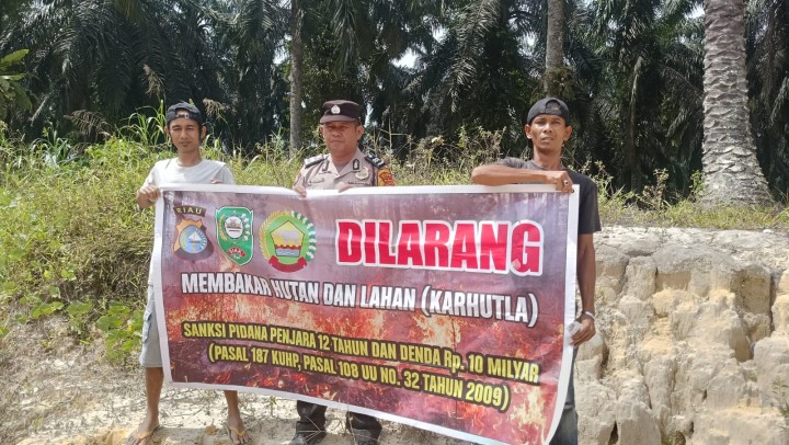 Antisipasi Karhutla, Bhabinkamtibmas Pasang Spanduk dan Edukasi Warga