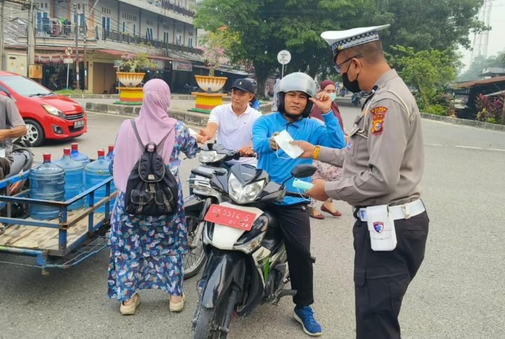 Antisipasi Dampak Asap Karhutla, Satlantas Polres Siak dan Puskesmas Bagikan Masker di Bundaran Kwalian